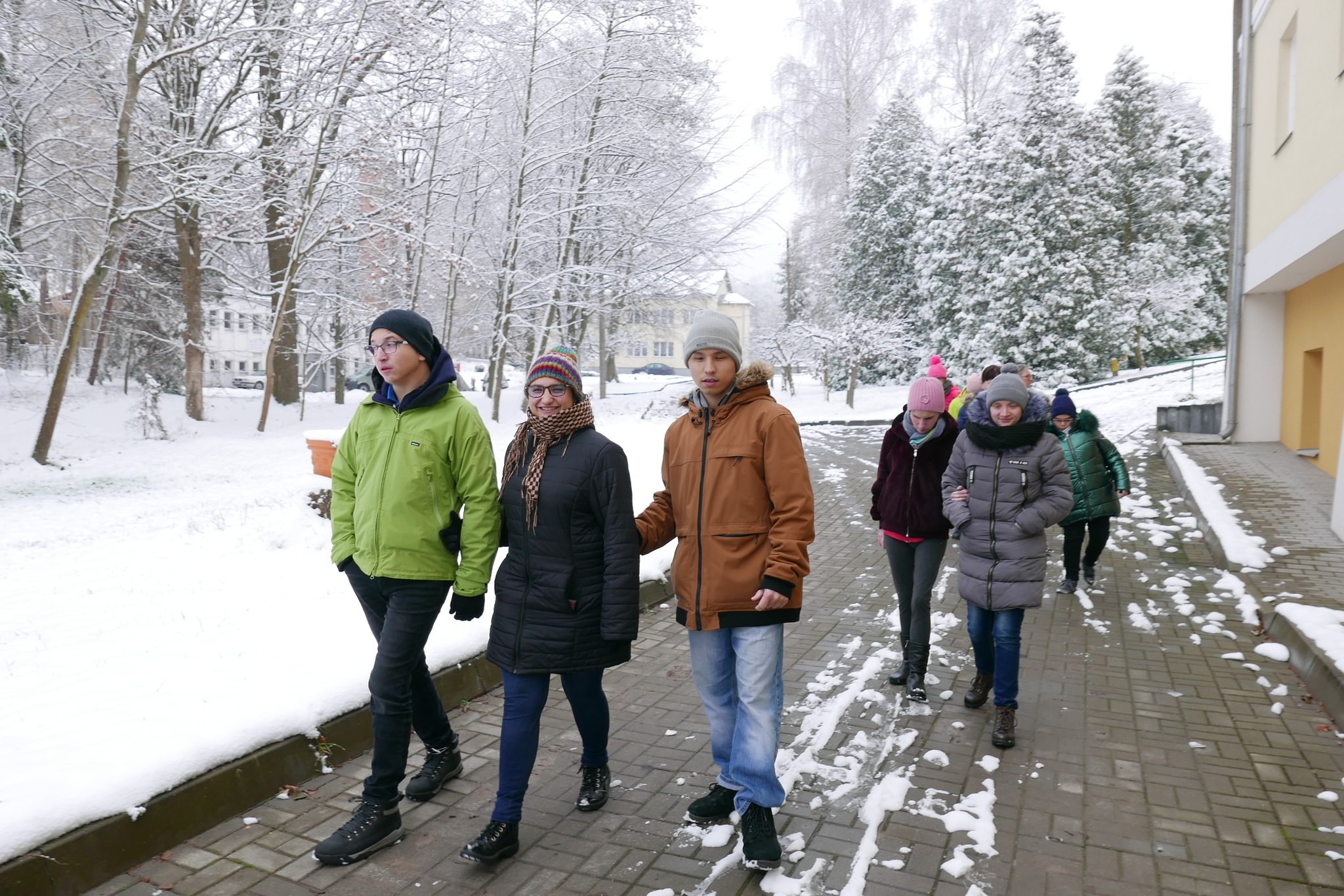 Uczniowie spacerują po terenie Domu Pomocy Społecznej.