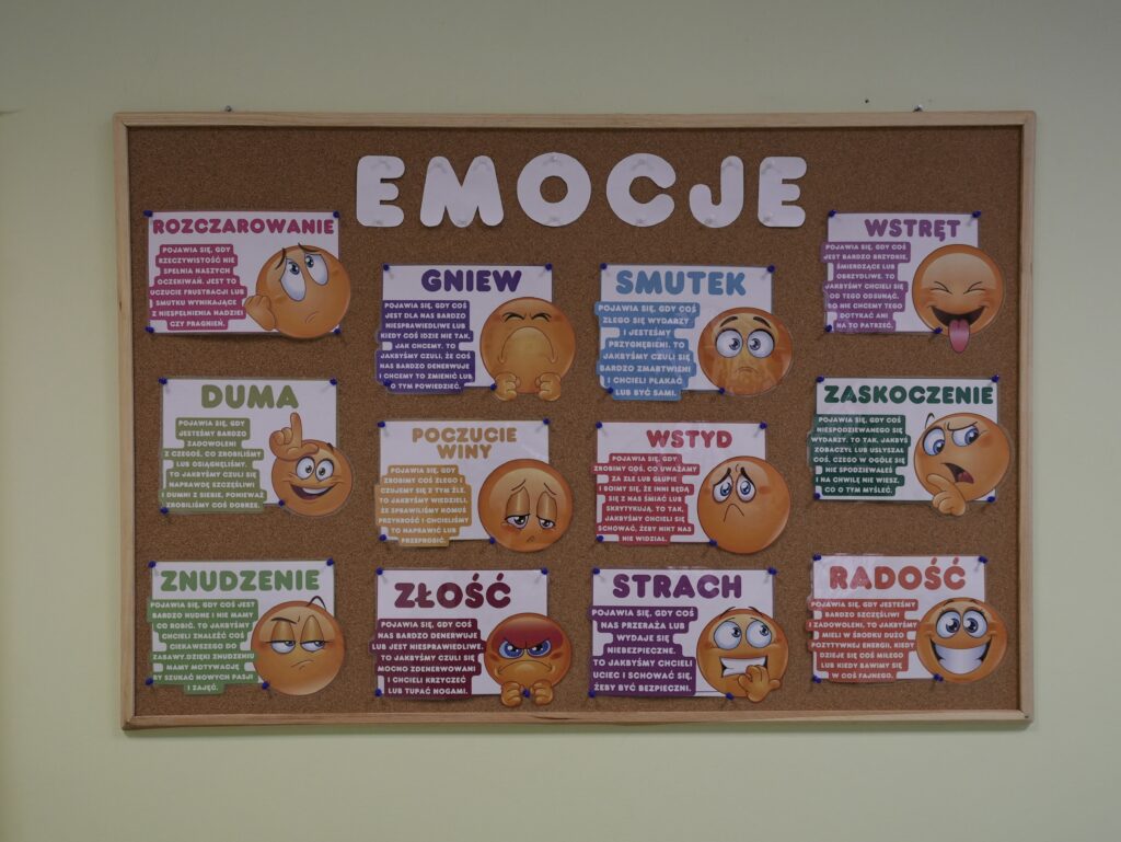 Tablica korkowa z kolorowymi emotikonami ilustrującymi emocje.