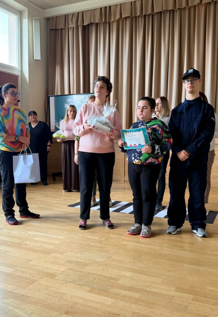 Kontynuacja wręczania nagród za konkurs plastyczny, w tle reszta uczestników.