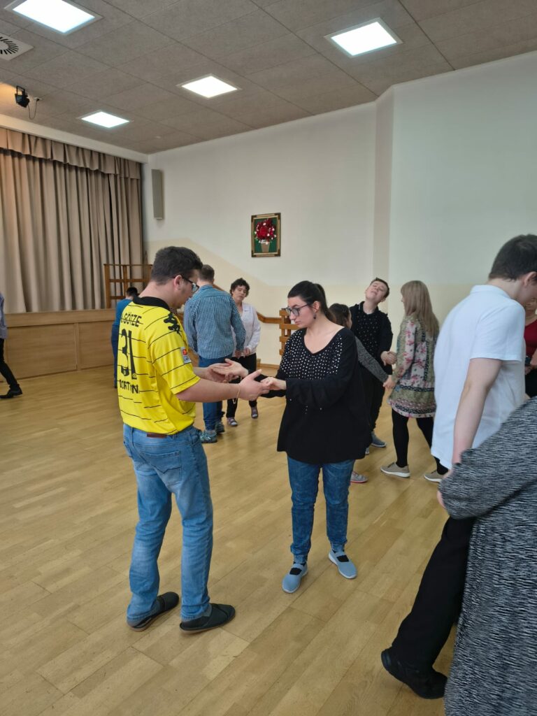 Tańczące ze sobą pary podczas zabawy tanecznej.