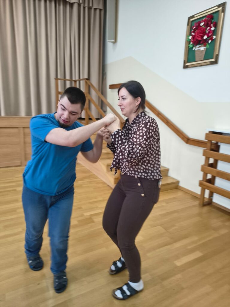 Młody mężczyzna tańczy z nauczycielką.