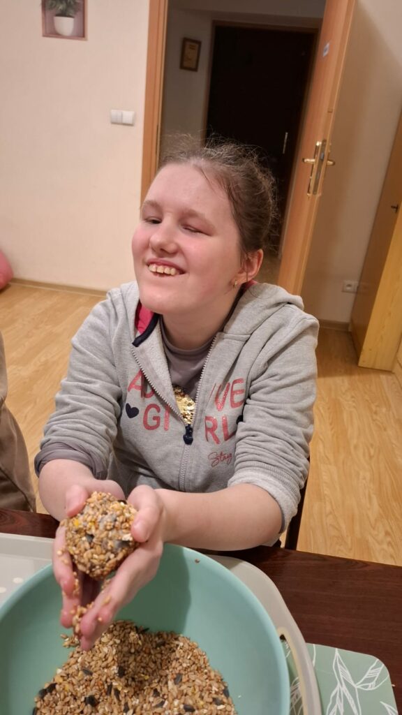 Uśmiechnięta dziewczyna trzyma w rękach kulę z ziaren.