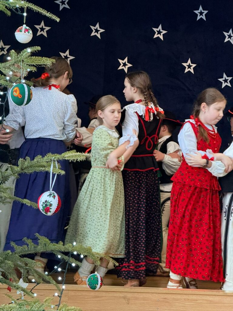 Grupa osób w regionalnych strojach podczas tańca.