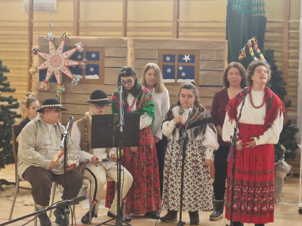 Grupa osób w strojach regionalnych podczas występu.