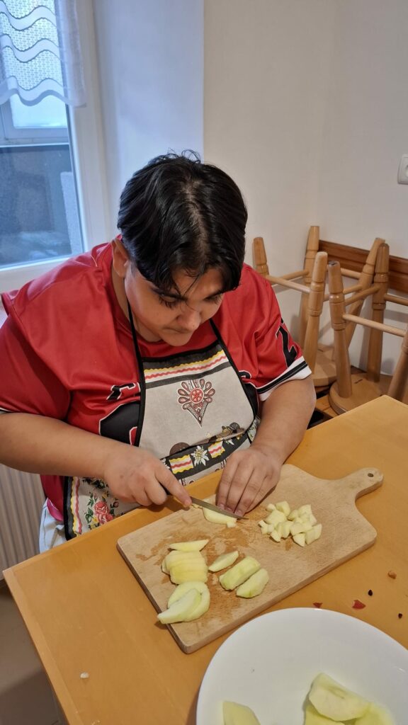 Chłopiec kroi jabłko w kostkę.