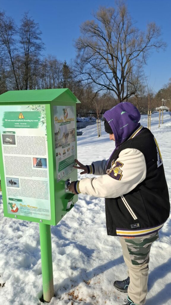 Młody mężczyzna korzysta z automatu "Ptasia karma".