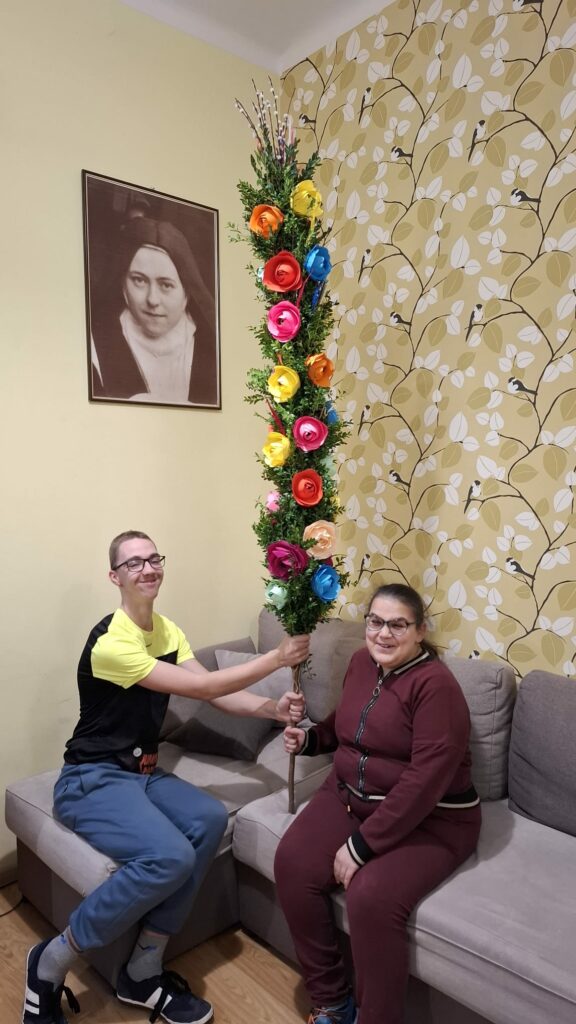 Uśmiechnięci chłopiec i dziewczyna prezentują gotową palmę.